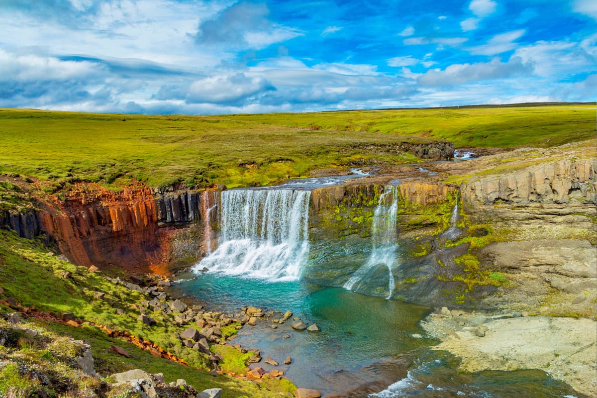 Waterfall and green highland landscape on the Waterfall Circle near Laugarfell in East Iceland.