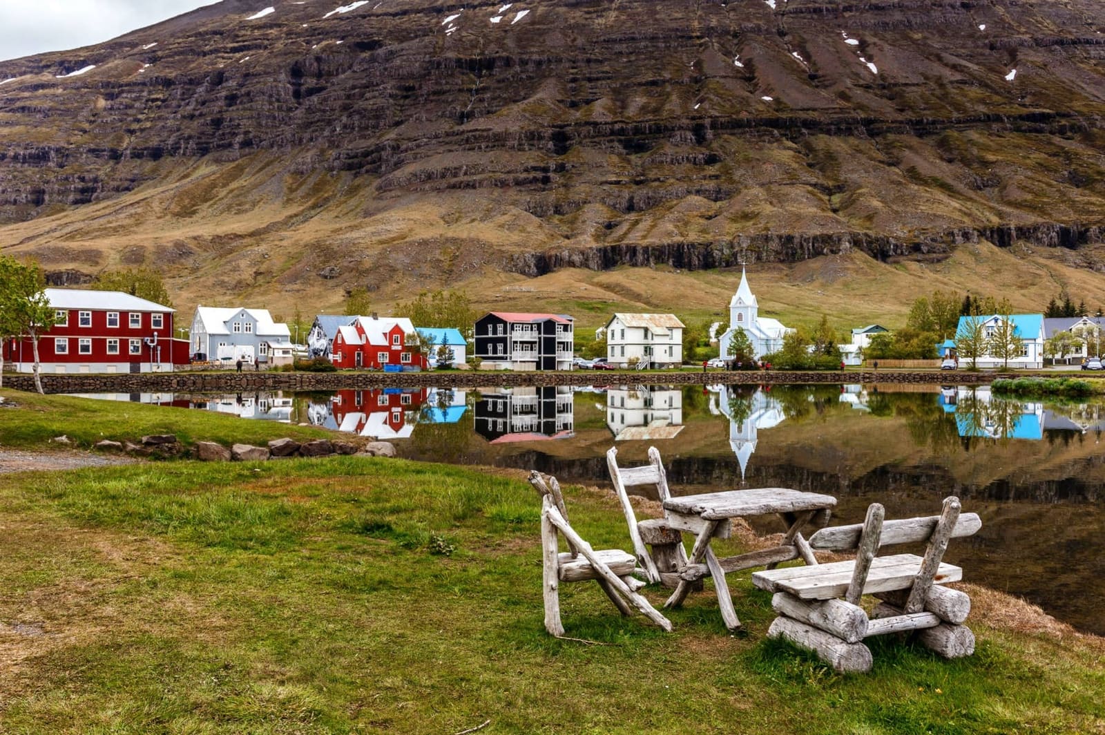 Colorful houses reflected in the water at Seyðisfjörður town center in East Iceland.