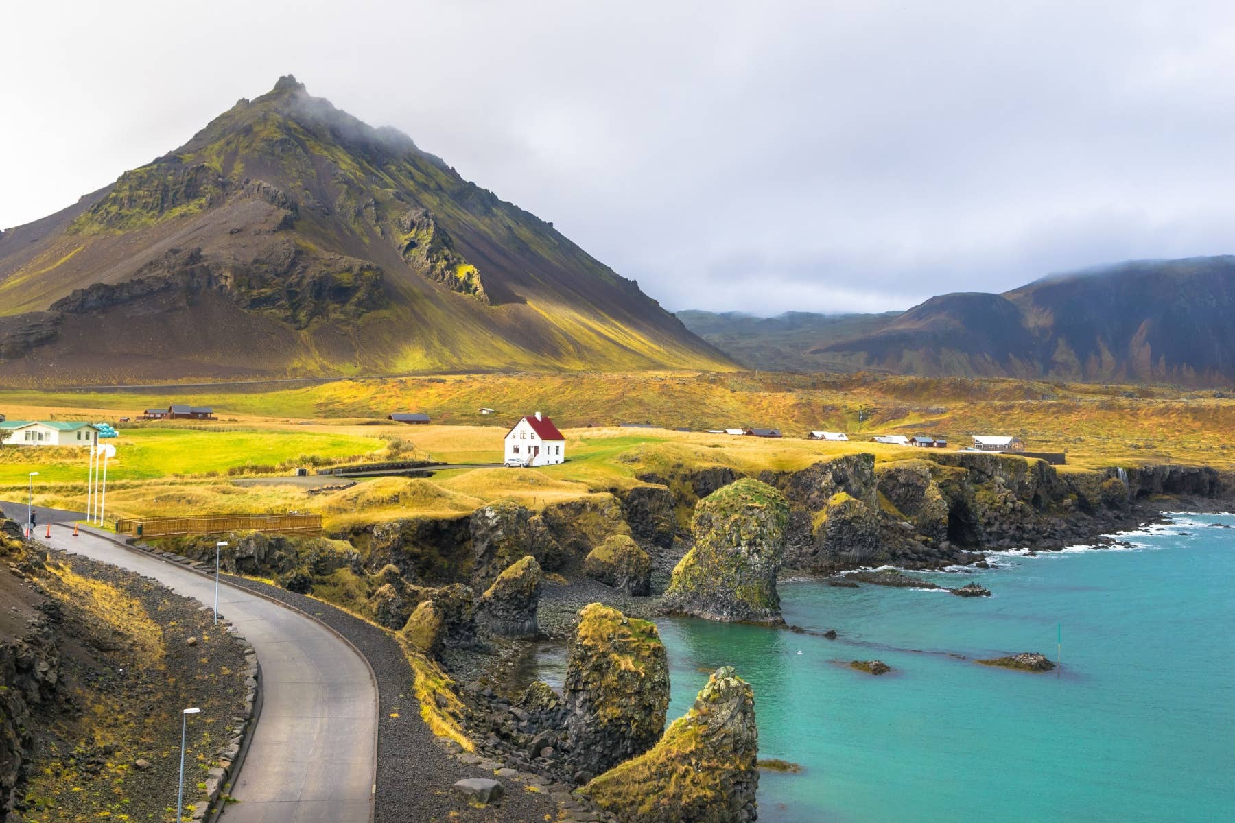 Coastal road below cliffs and mountains in Snæfellsjökull National Park.