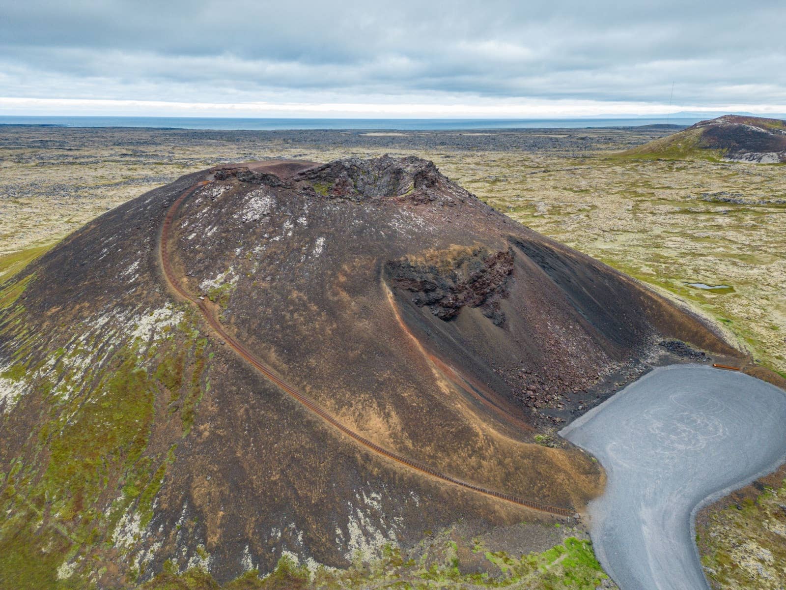 Saxhóll crater rising from lava fields inside Snæfellsjökull National Park.