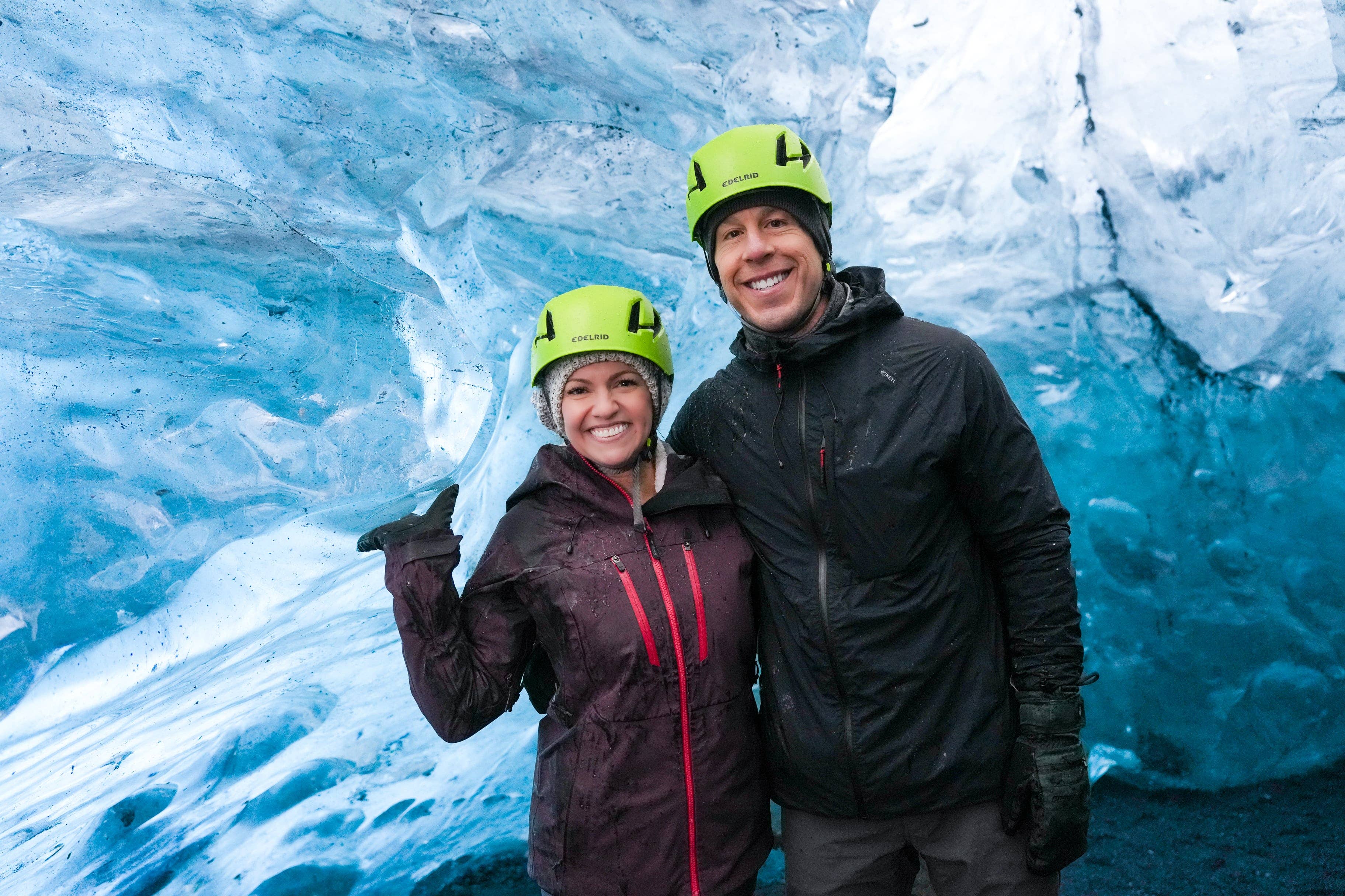 Helmeted visitors standing inside a blue Crystal Ice Cave chamber