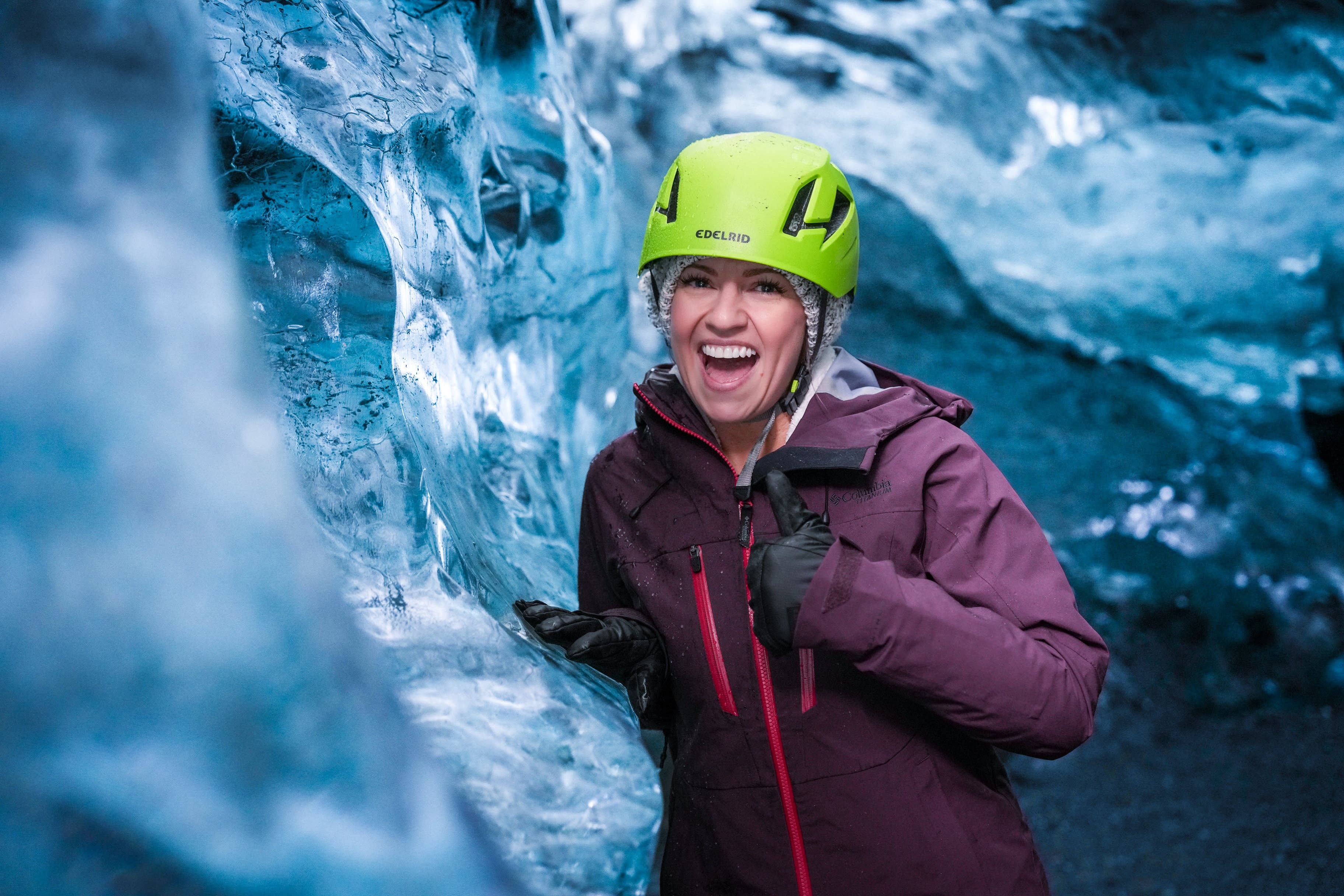Guide and visitors moving through blue ice formations at Crystal Ice Cave