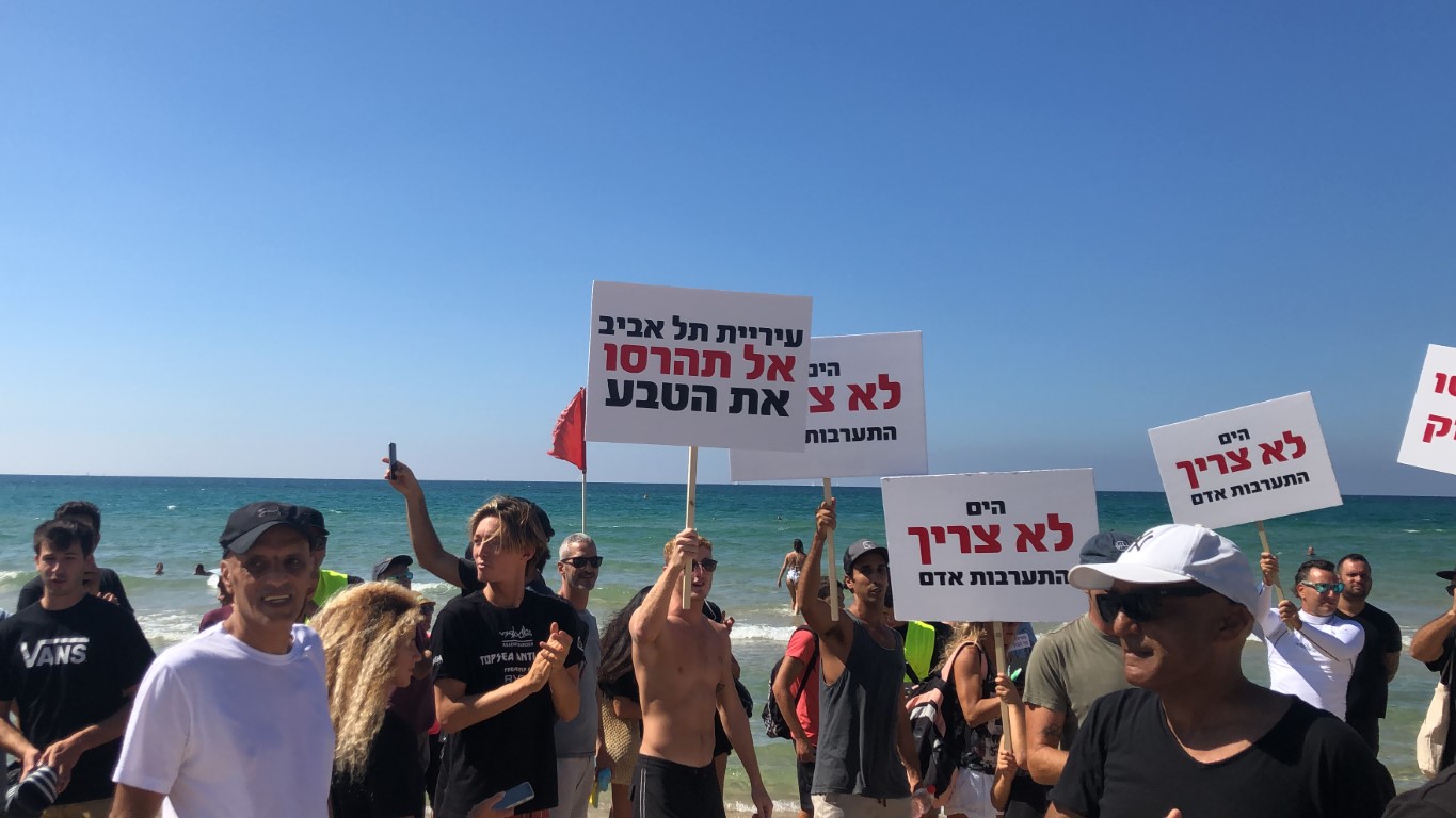 כמאה מפגינים השתתפו ביום שישי האחרון בצעדת מחאה בחוף הצוק, נגד כוונת עיריית תל אביב לבנות גיאוטיוב הרסני בחוף