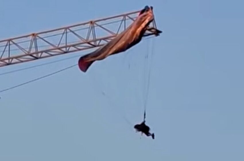  (VIDEO) Un parapantist a rămas suspendat la 60 de metri după ce parașuta sa s-a încurcat într-o macara, în China