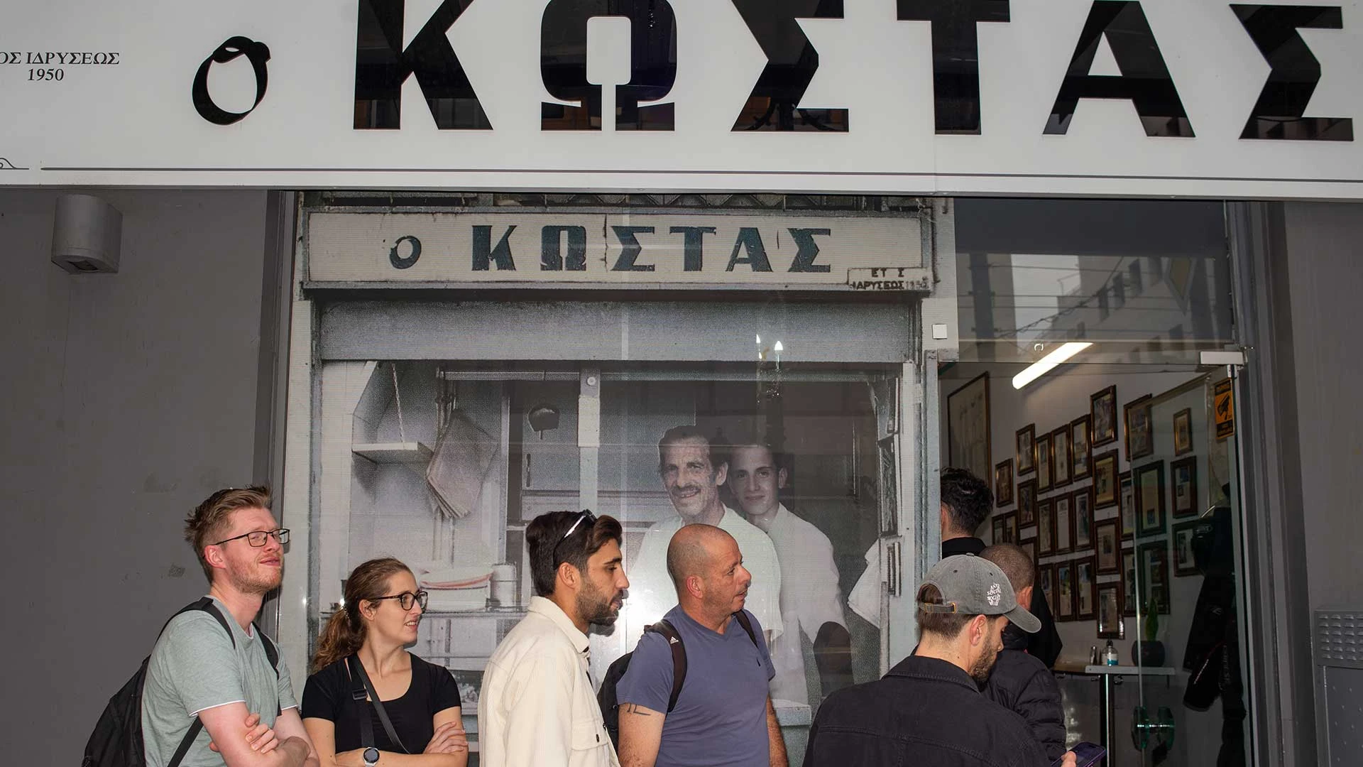 A line of people waiting outside the 'O Kostas' souvlaki shop in Athens.
