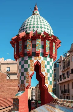 A colorful dome of Casa Vicens in Barcelona, with a green and white checkered dome and ornate floral tiles.