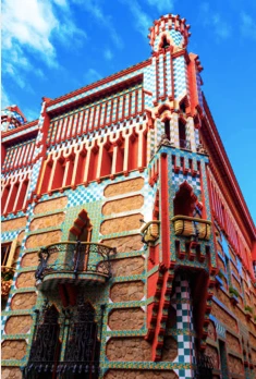 The ornate and colourful tiled facade of Gaudí's Casa Vicens in Barcelona, seen from a low angle against a blue sky.