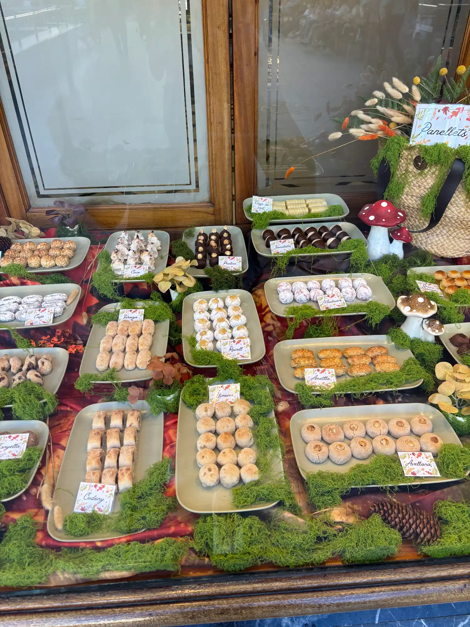 Bakery display window in Barcelona with platters of traditional Catalan panellets sweets.