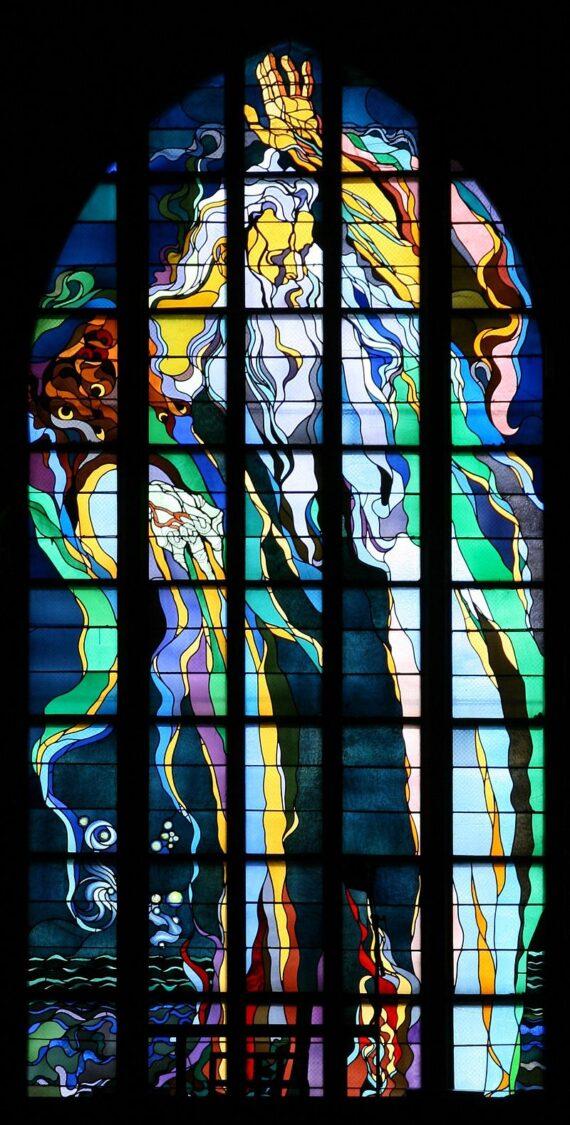 Vibrant stained glass window depicting abstract forms and figures in the Church of St. Francis in Krakow.