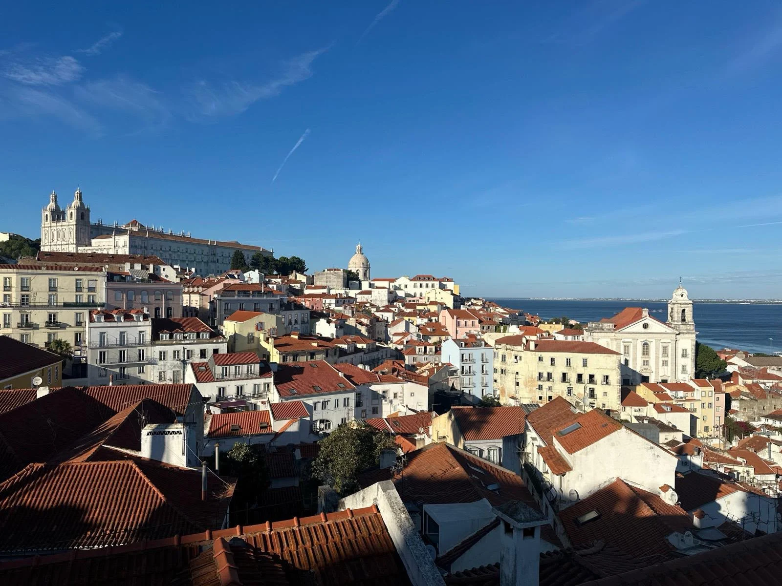 View over the terracotta rooftops of the Alfama district in Lisbon on a sunny day.