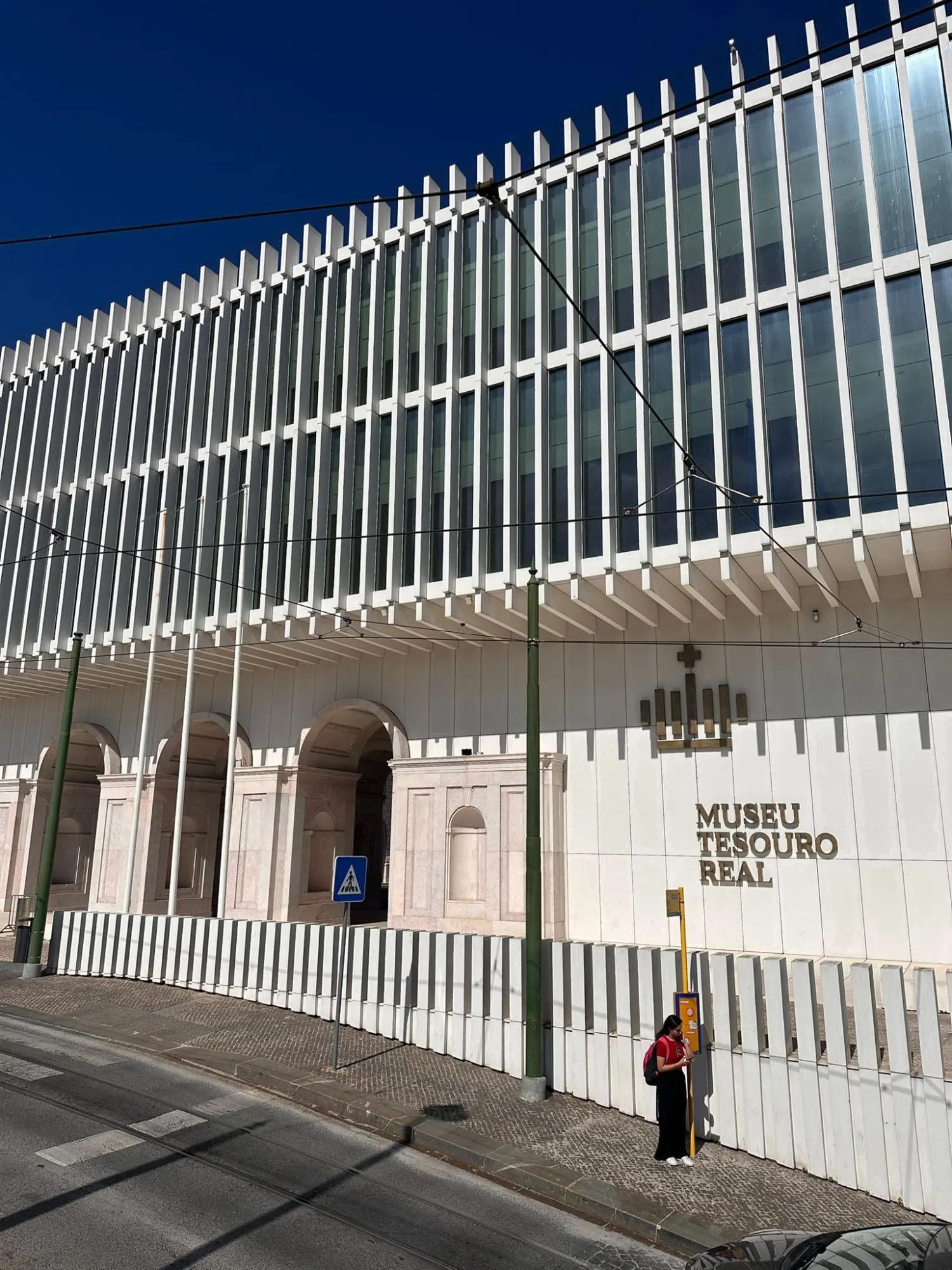The modern white facade of the Royal Treasury Museum in Lisbon, seen from across the street on a sunny day.