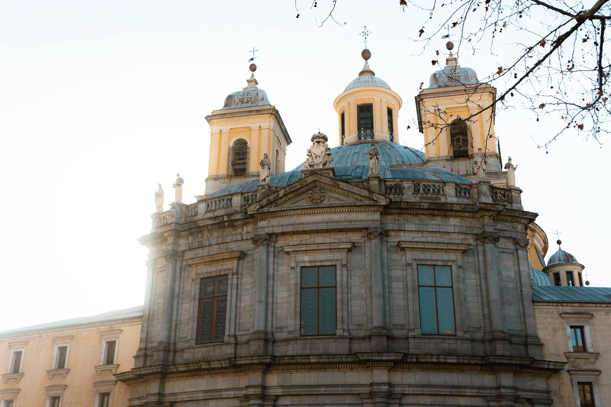 The stone facade of the Royal Basilica of Saint Francis the Great in Madrid, with its large dome and towers.