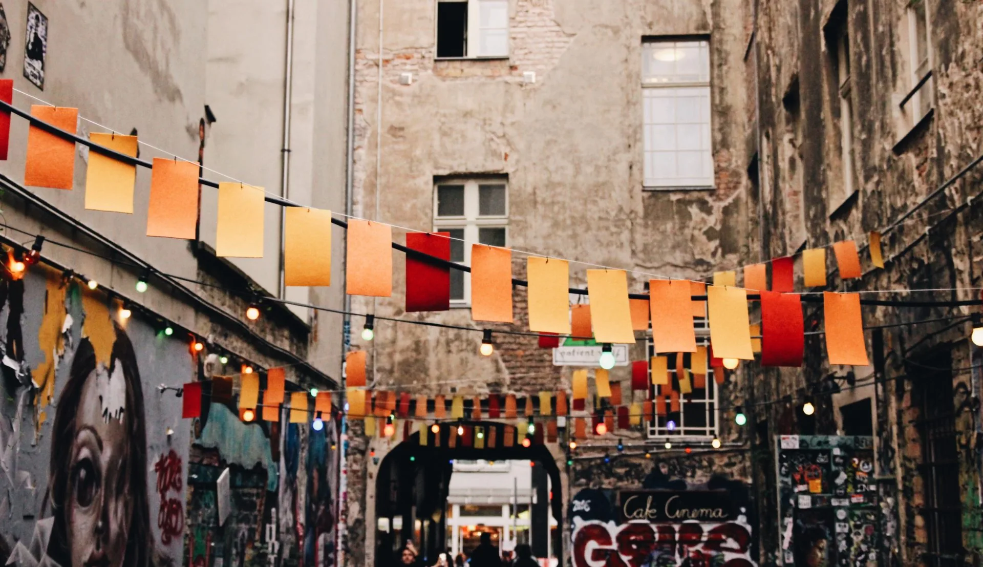 Colorful flags and string lights illuminate a charming Berlin alleyway.
