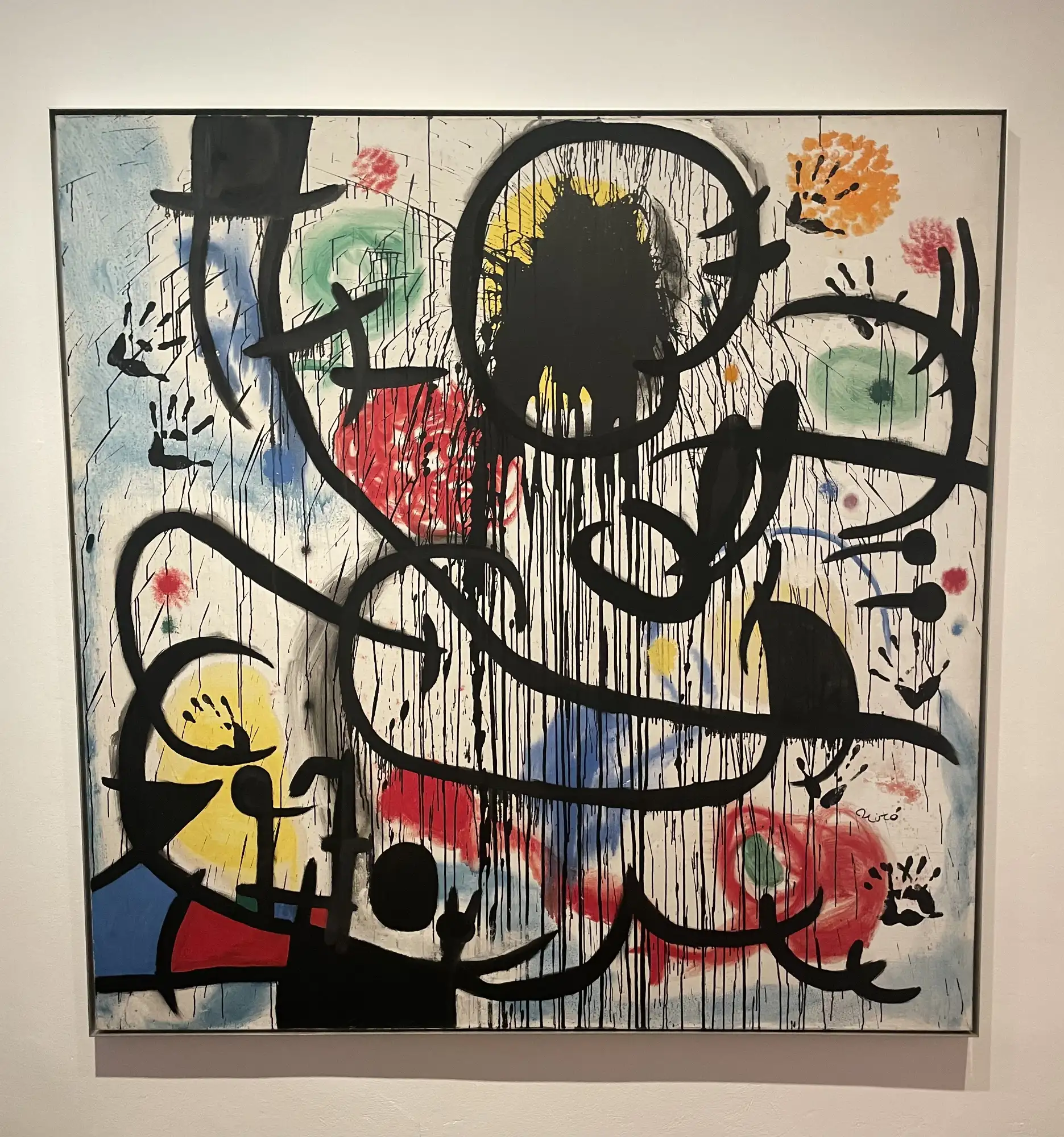 Abstraktes Gemälde von Joan Miró mit tropfenden schwarzen Linien, farbigen Formen in Rot, Gelb, Grün und Handabdrücken.