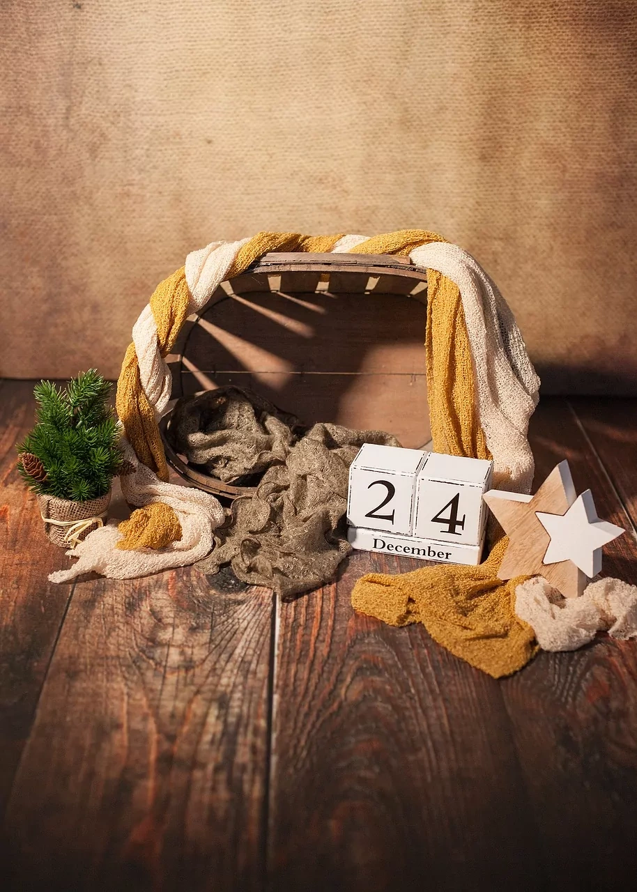 Rustikales Weihnachtsarrangement mit Holzkiste, drapierten Stoffen, kleinem Nadelbaum, Holzstern und Kalender mit dem 24. Dez