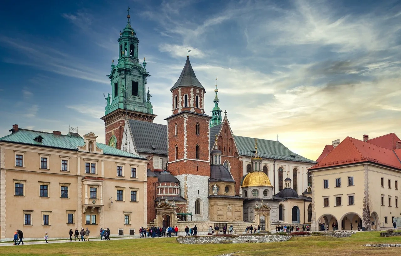 Der Komplex der Wawel-Kathedrale an einem teilweise bewölkten Tag, mit seinen verschiedenen Türmen und Kapellen von einer Wie