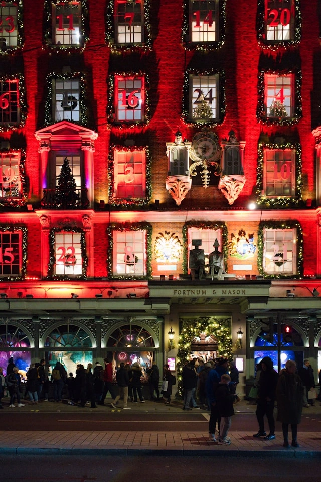 Exterior of Fortnum & Mason in London, illuminated in red and decorated as a giant advent calendar at night.