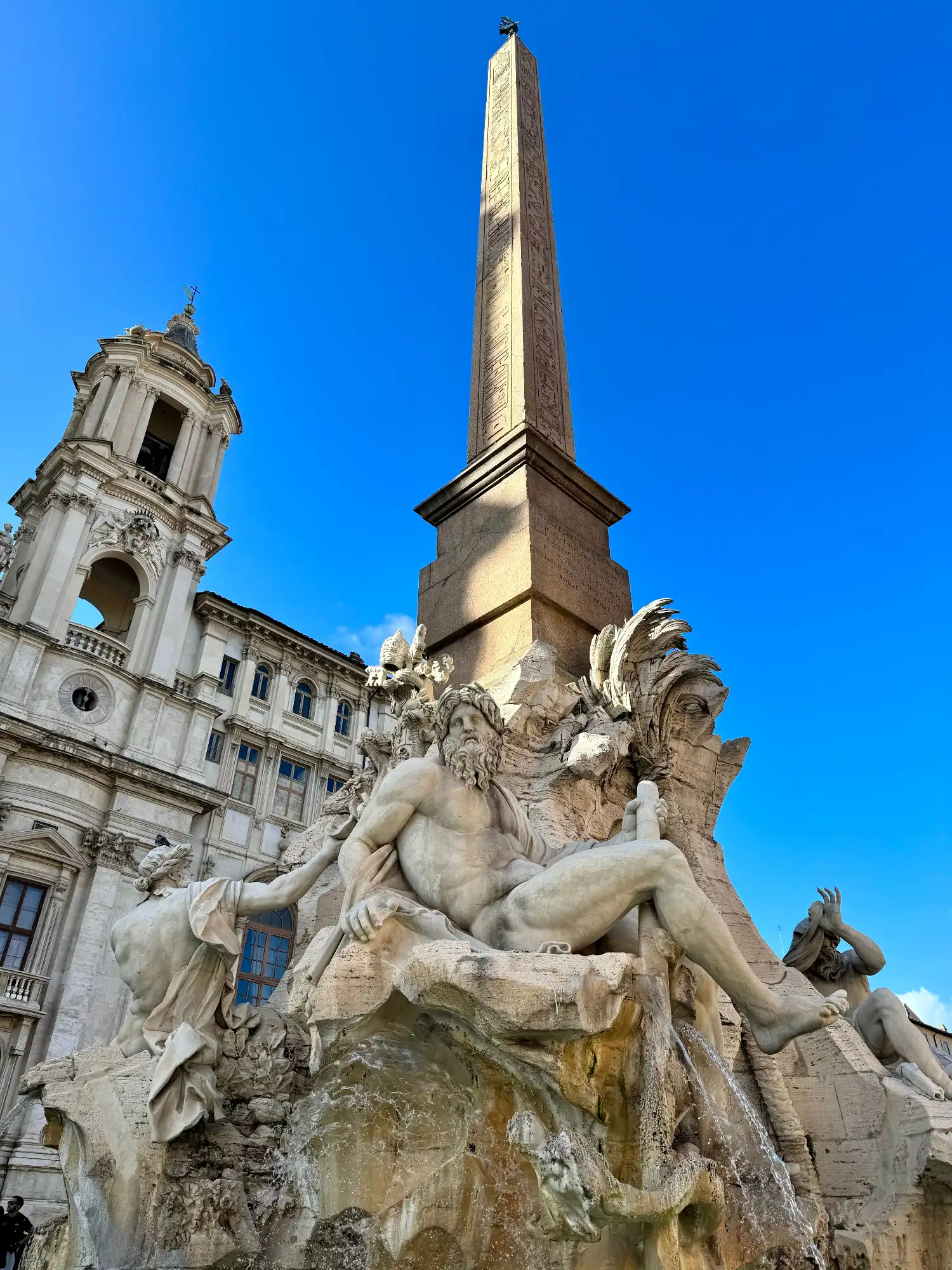 The Fountain of the Four Rivers with marble statues and an Egyptian obelisk in Piazza Navona, Rome.