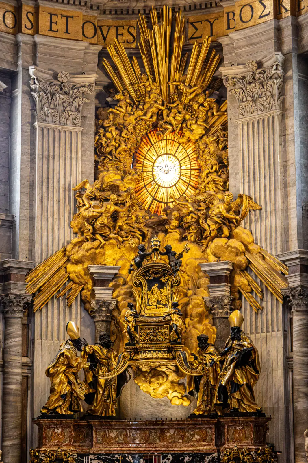 Gilded bronze monument with a throne, sculpted figures, and an illuminated dove window in St. Peter's.