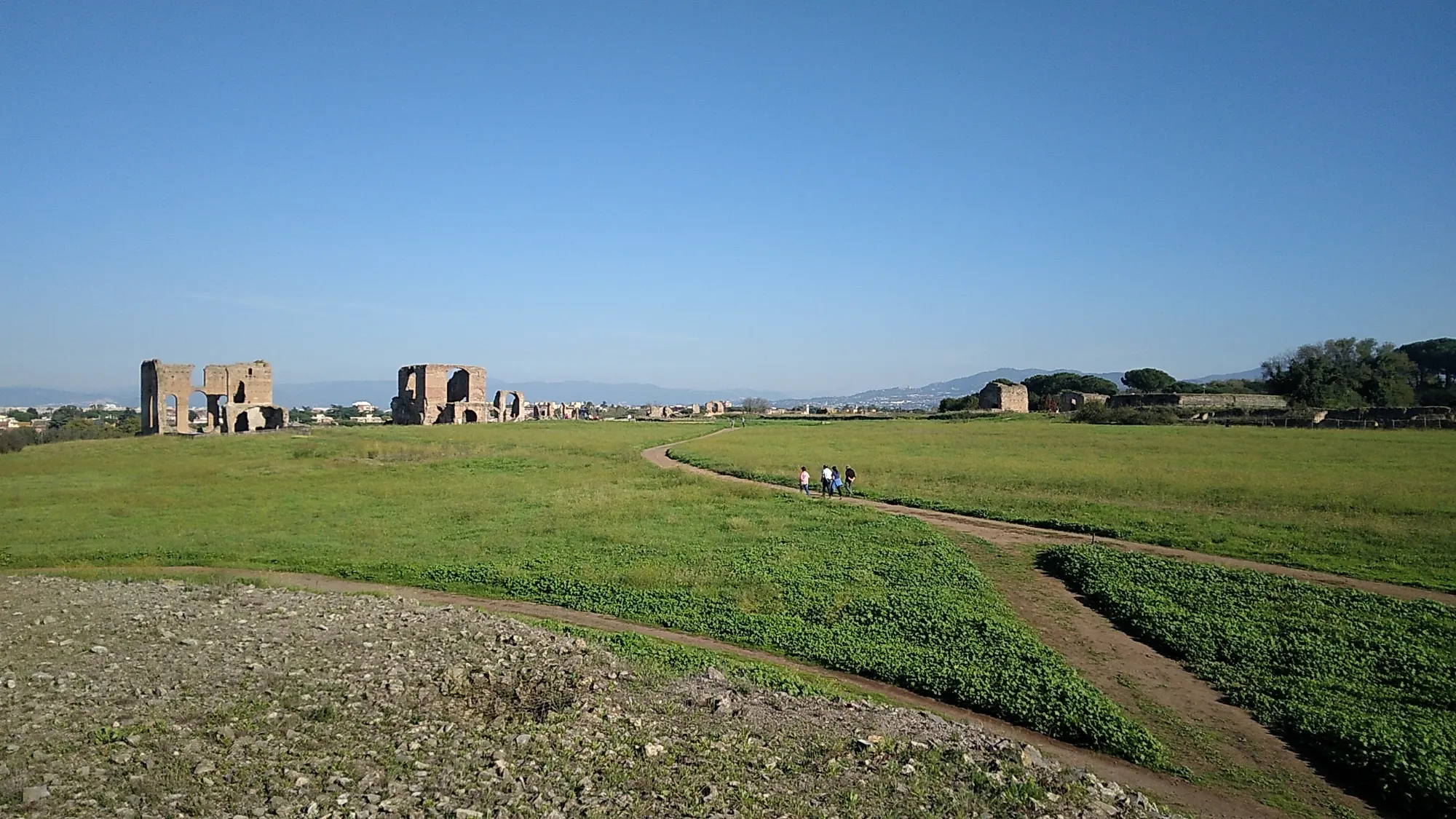 Roman ruins in the Park of the Aqueducts in Rome on a sunny day with a clear blue sky.