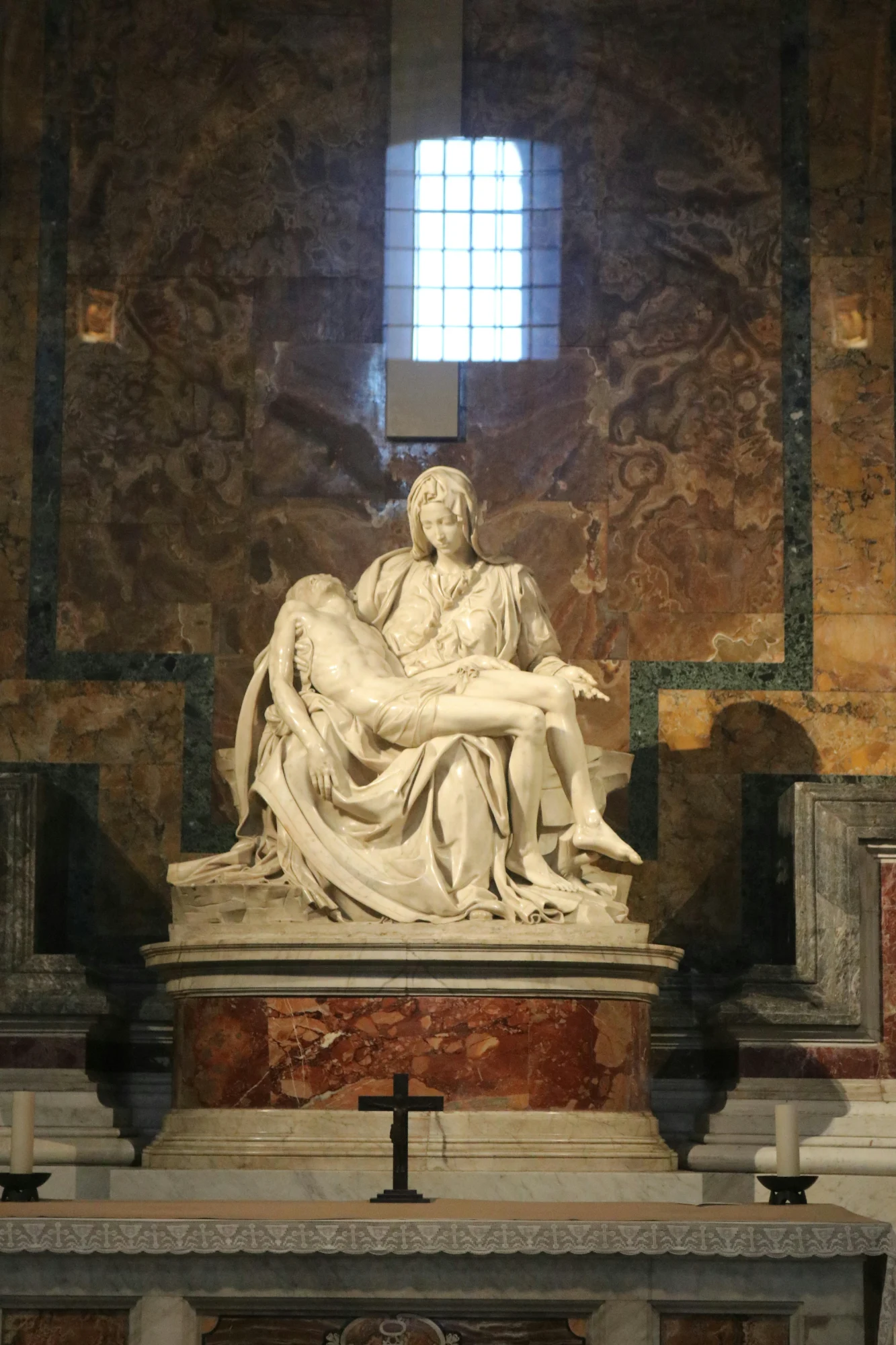 Michelangelo's Pietà sculpture in St. Peter's Basilica, showing the Virgin Mary holding the body of Christ.