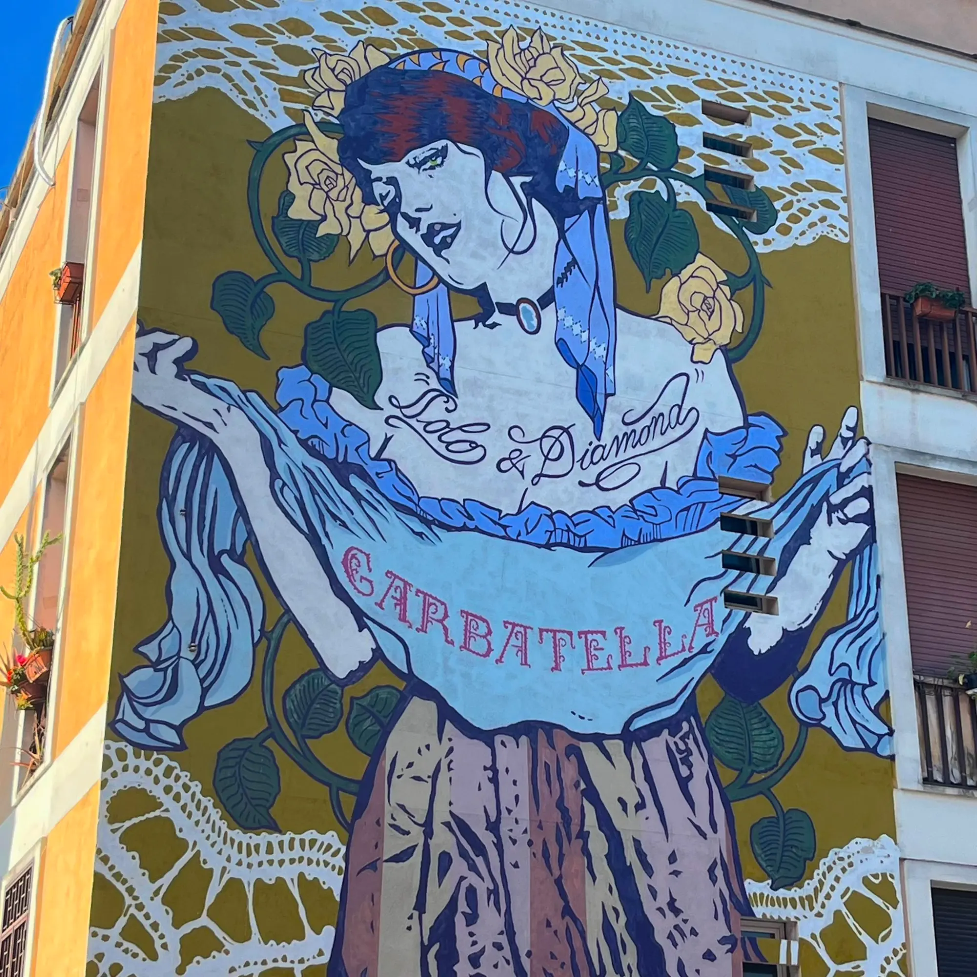 Large mural of a woman in a vintage style on the side of a building in Rome's Garbatella neighbourhood.