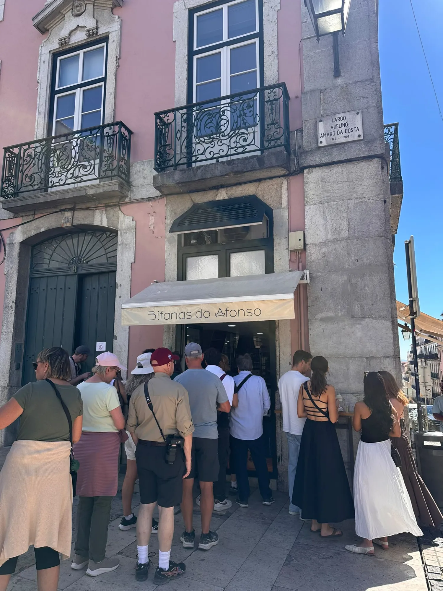 People queued outside the Bifanas do Afonso sandwich bar at Largo Adelino Amaro da Costa in Lisbon.