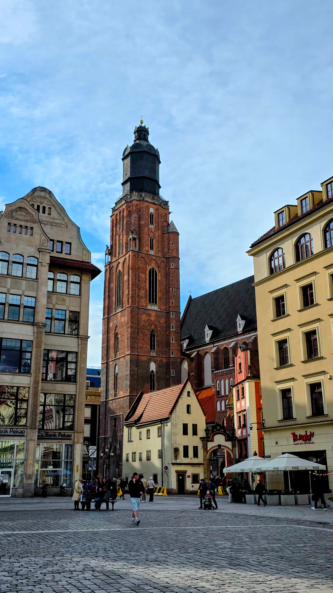 Tall, gothic brick tower of St. Elizabeth's Church over the market square in Wroclaw on a sunny day.