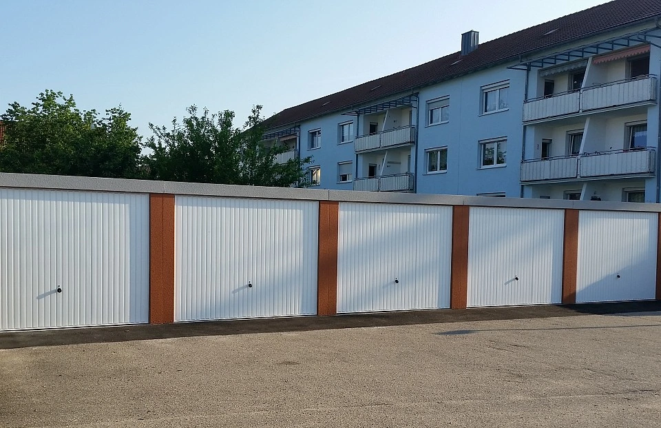 Fünf neue Garagen mit weißen Toren vor einem Wohngebäude in der Goethestraße 13 in Plattling